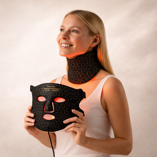 Woman wearing the LED neck attachment and holding the Nurtura Red Light Therapy Mask with glowing red lights against a plain background